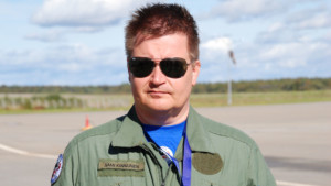 Lentopelastusseuran koulutuspäällikkö Sami Kinnunen kasvokuvassa lentokentällä aurinkolasit päässä.