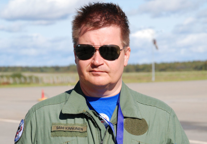 Lentopelastusseuran koulutuspäällikkö Sami Kinnunen kasvokuvassa lentokentällä aurinkolasit päässä.