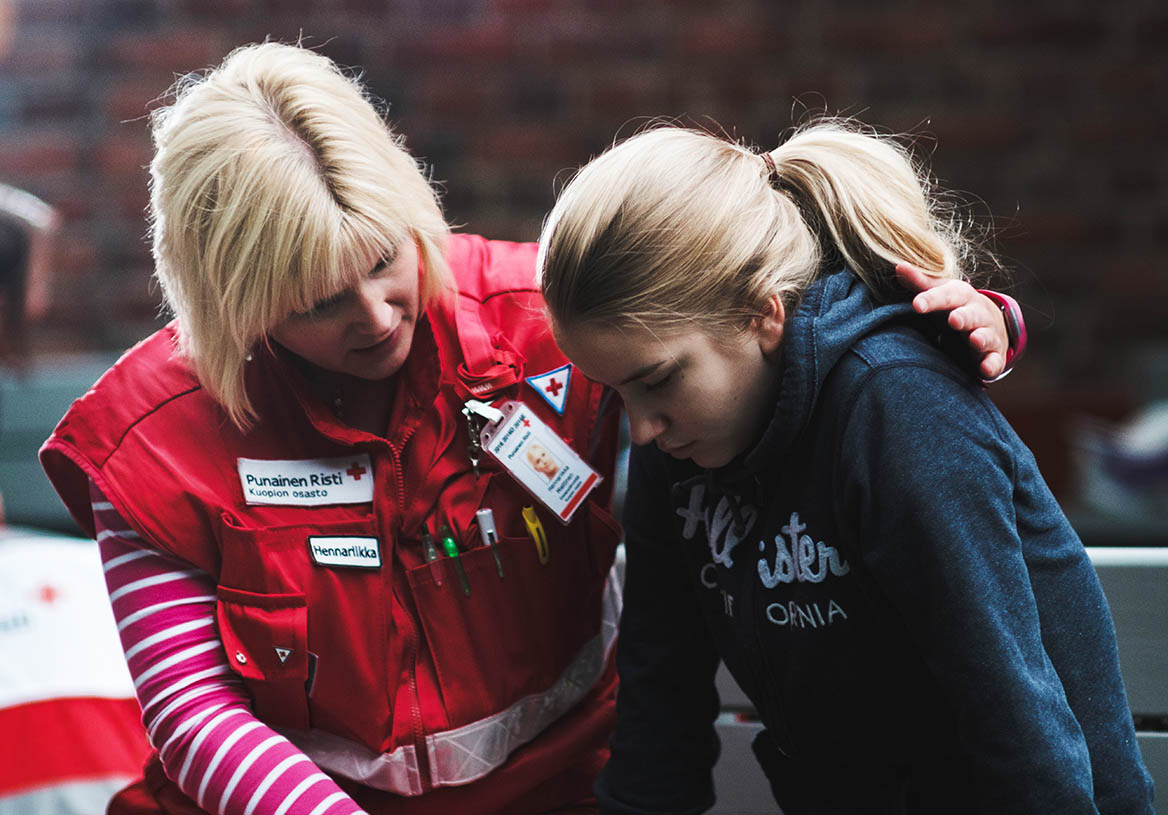 Suomen Punaisen Ristin vapaaehtoinen auttamassa nuorta kriisissä.