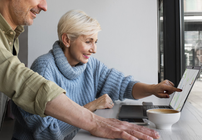Kaksi henkilöä työskentelee tietokoneella.