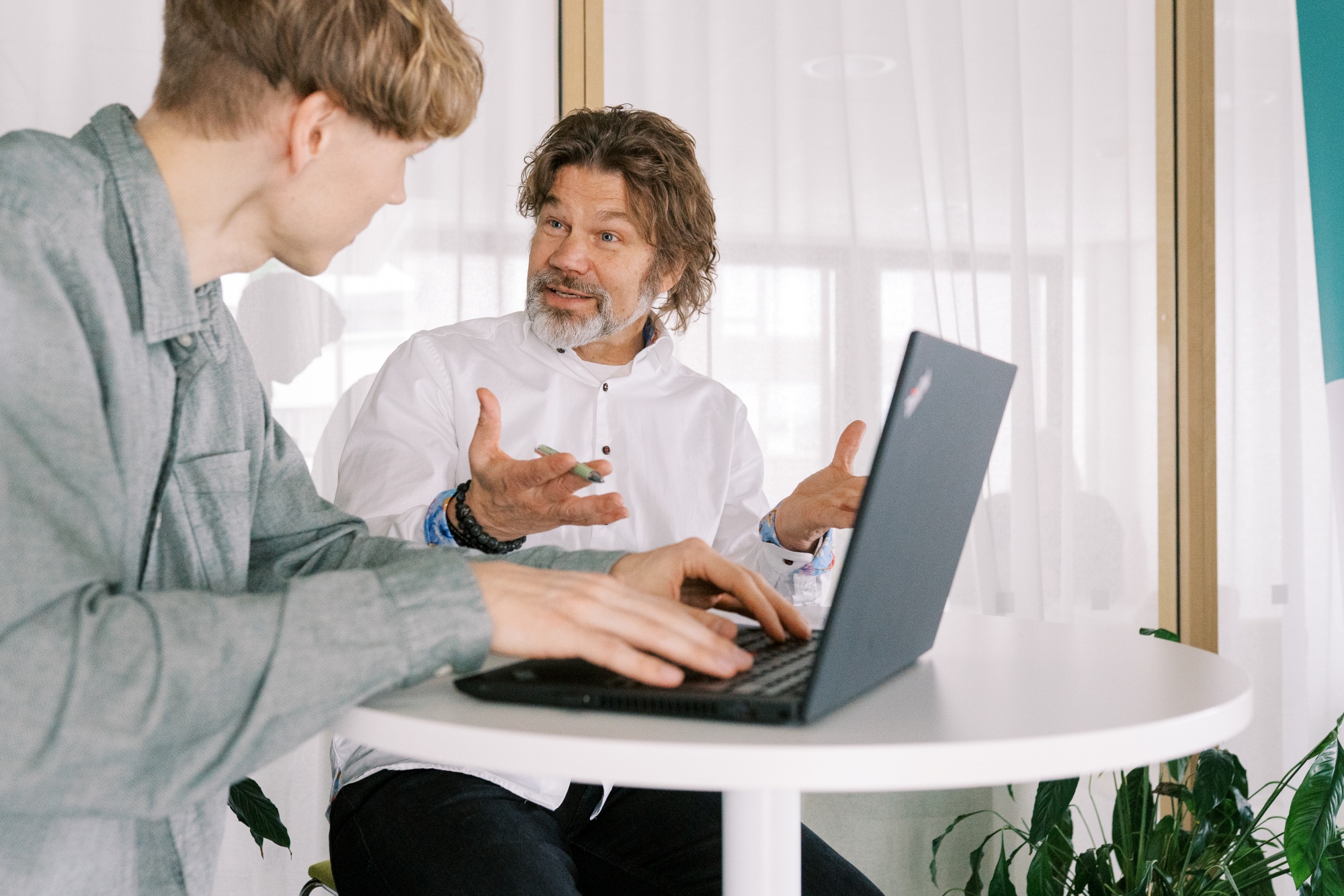 Kaksi henkilöä keskustele e tietokoneen edessä.