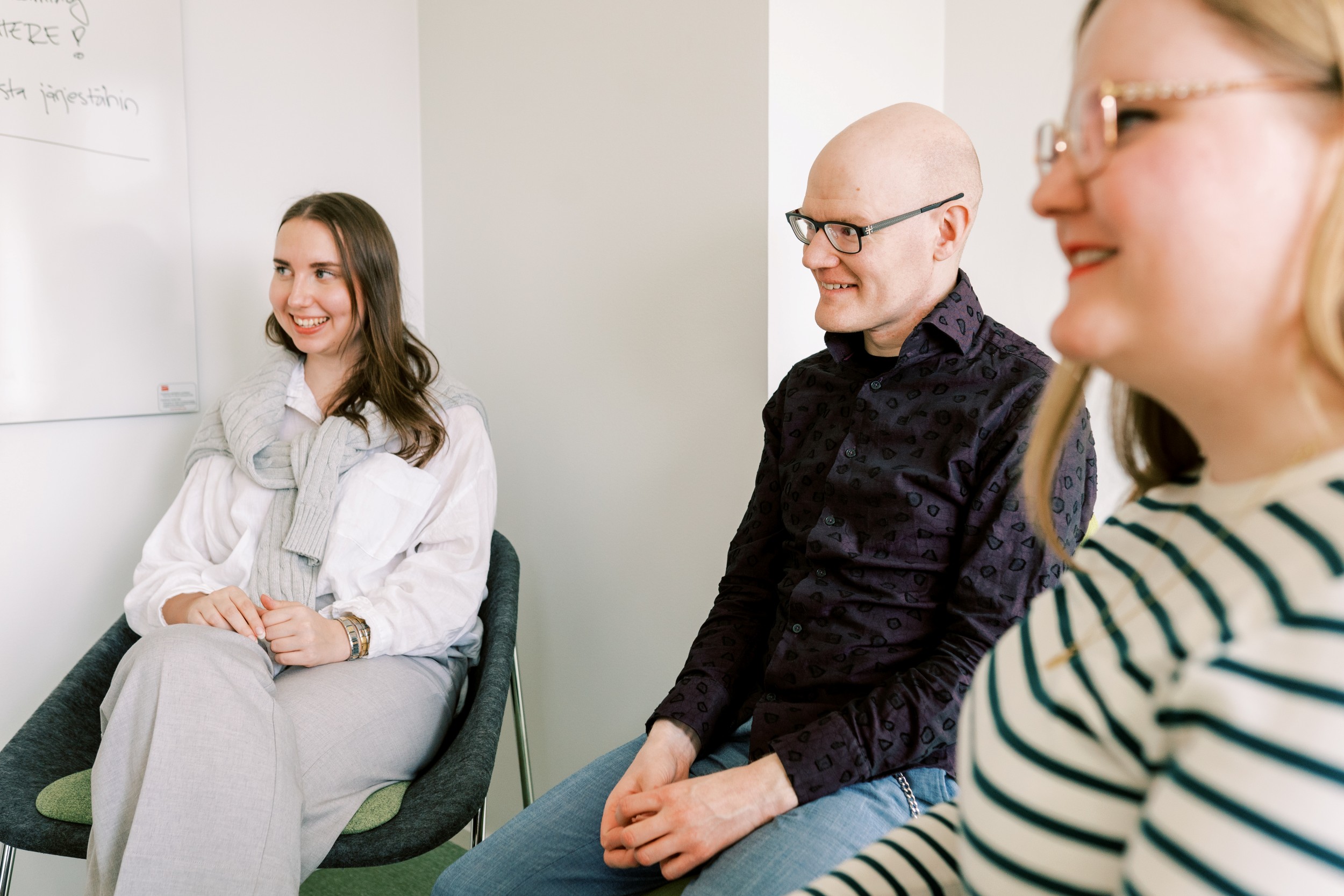 Kolme henkilöä keskustelee.